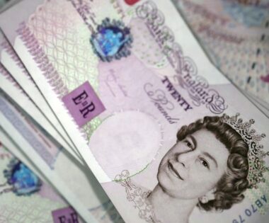 Close-up of several British £20 banknotes, featuring the Queen's portrait. The notes are fanned out.