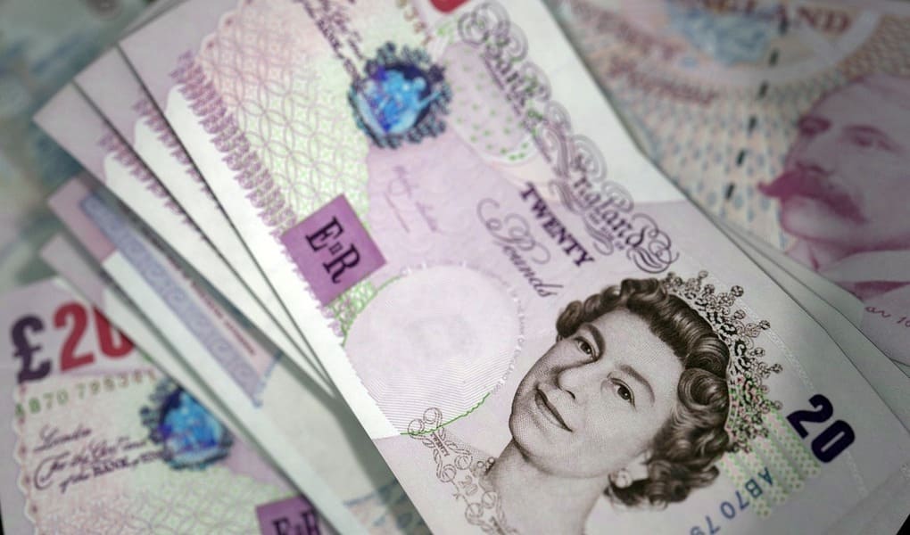 Close-up of several British £20 banknotes, featuring the Queen's portrait. The notes are fanned out.