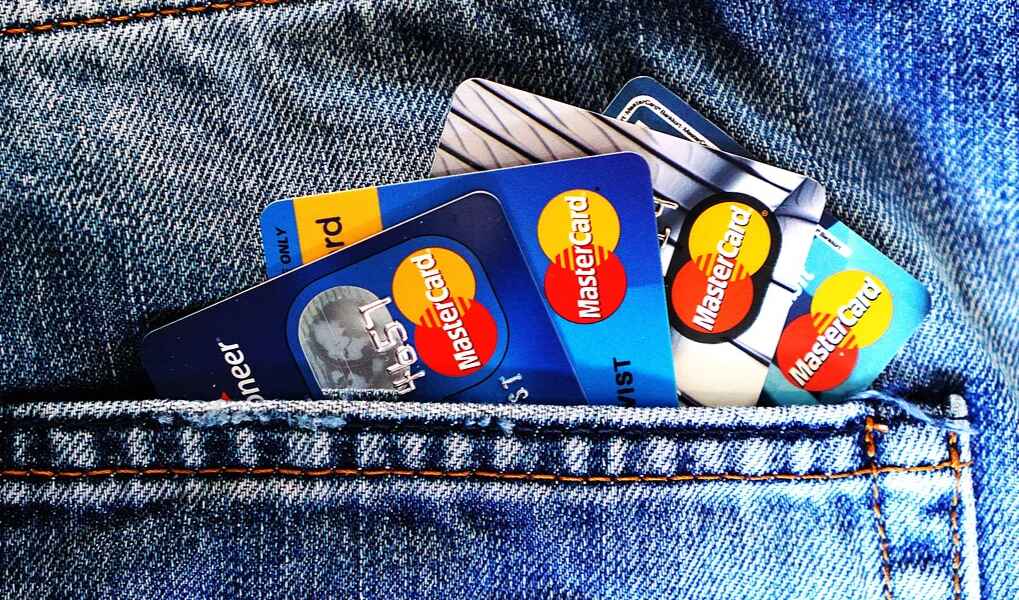 Credit cards visible in the pocket of a pair of blue denim jeans, showcasing a casual style and everyday convenience, conveying a theme of finance and accessibility.